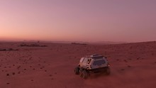 Mars Rover With Colonists Travelling Across The Surface Of Mars At Dusk