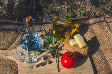 Cretan food with virgin olive oil, Olives,Cretan Barley Rusks, local cheese and carafe of cretan raki.