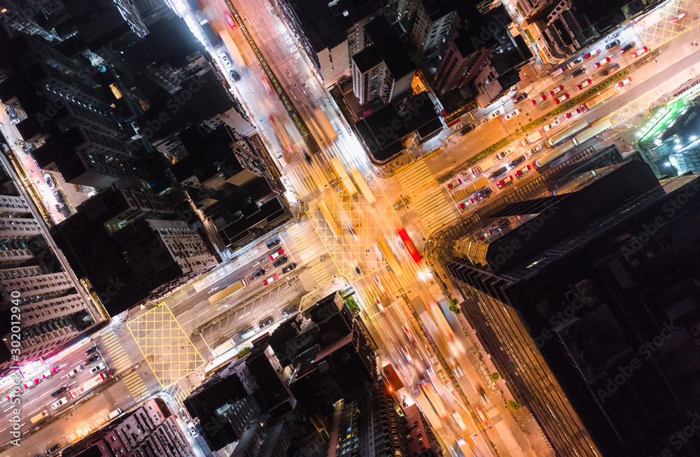 Car, taxi, and bus traffic on road intersection at night in Hong Kong downtown district, drone aerial top view. Street commuter, Asia city life, or public transportation concept - obrazy, fototapety, plakaty 