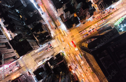 Fotomural Car, taxi, and bus traffic on road intersection at night in Hong Kong downtown district, drone aerial top view