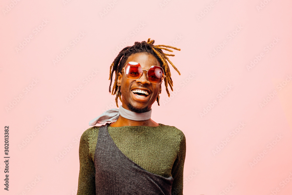 Portrait of a happy and cheerful young man laughing, isolated on pink - obrazy, fototapety, plakaty 