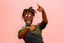 Portrait Of A Fun Young Man With Mouth Open Laughing And Pointing At Camera, Isolated On Pink