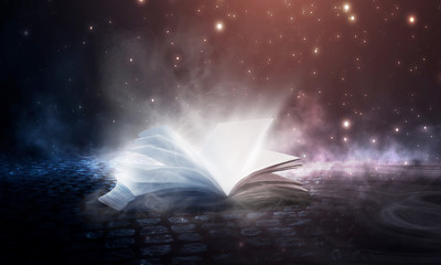 Wall Mural - an open book on a wooden table under the night sky against a dark forest. magical radiance. night sc