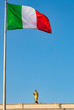 The Italian flag with in the background a gold Christ statue