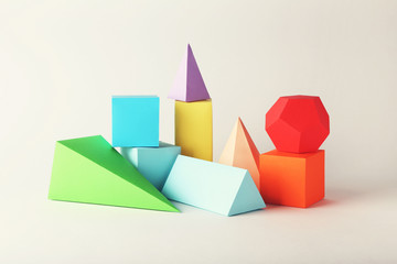 Colorful paper geometric figures on grey background