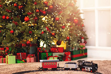 Christmas Toy Train In Background Illumination And New Year Tree