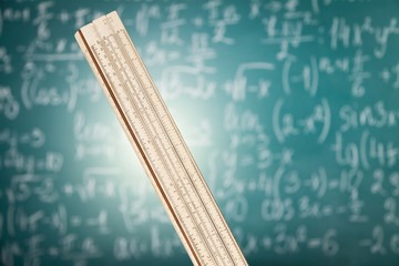 Wall Mural - Wooden ruler on the background of a blackboard with formulas