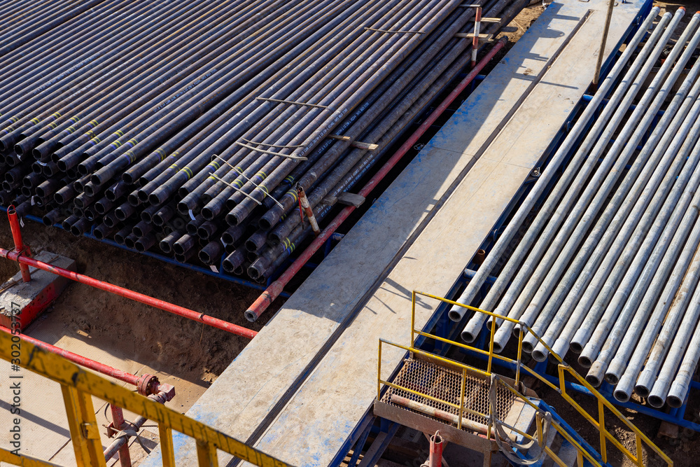 Pipes In Rigs Down view through Rig floor stairs to pipes on pipe rack next to ...