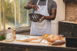 © denis_vermenko - Baking process. Cheerful dark skinned African American male wears apron, kneads dough with great enthusiasm, being content to recieve praise from chef for endeavour and hard work in restaurant.