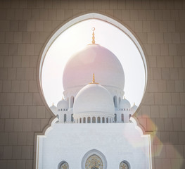 Wall Mural - Beautiful view through a white marble arch at Sheikh Zayed Mosque in Abu Dhabi, United Arab Emirates. sunny day