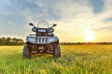 Gray ATV On Grass In Summer At Sunset With Copy Space. Beautiful Quad Bike At Sunset In Summer Front Side View