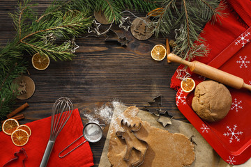 Baking background. Ingredients and kitchen tools for preparation of the Christmas cookies. Christmas atmosphere on a dark wood background, top view. Flat lay