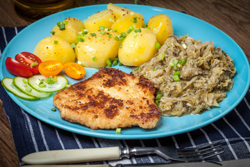 Wall Mural - Fried pork chop, baked potatoes and fried young cabbage.