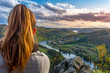 Beautiful girl enjoying life and watching the river, mountains and hills during sunset on the viewpoint (Zduchovice, Solenice, Altán view, hidden gem among travel destinations in Czech republic)