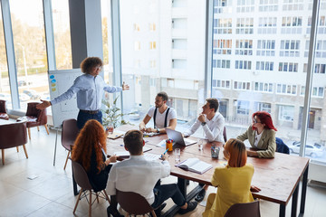 Wall Mural - Working, discussion process in business center. Young leaders in formal wear gathered in conference office with panoramic view on city