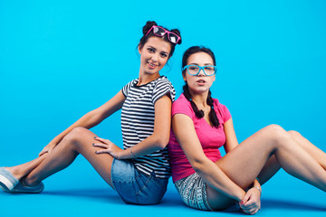 lifestyle people concept: two pretty young school teenage girls having fun happy smiling on blue background