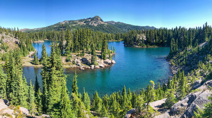 Wall Mural - a high elevation volcanic mountain lake surrounded by hills and green trees.