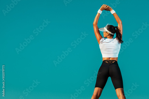 Fotografía Sporty and fit young woman athlete doing yoga training on the sky background
