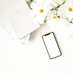 Wall Mural - Business, freelance, blogger concept. Mock up, empty, copy space. Mobile phone on white table with daisies and notebooks.