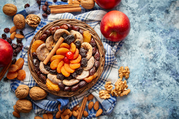 Composition of dried fruits and nuts in small wicker bowl placed on stone table