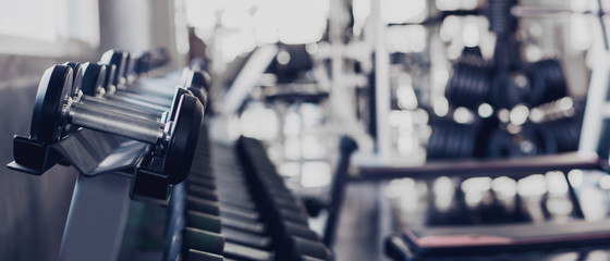 gym interior background of dumbbells on rack in fitness and workout