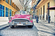 Old Buik pink car parked in a street of havana city