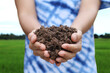 Handful of arable soil in hands of responsible farmer, close up, selective focus