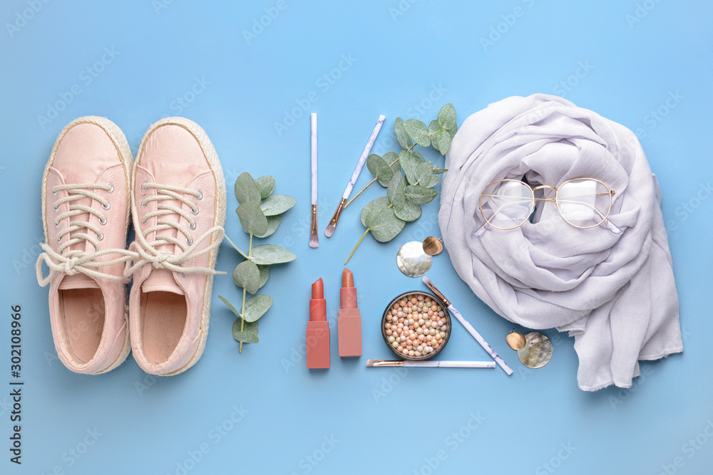 Female accessories with decorative cosmetics on color background