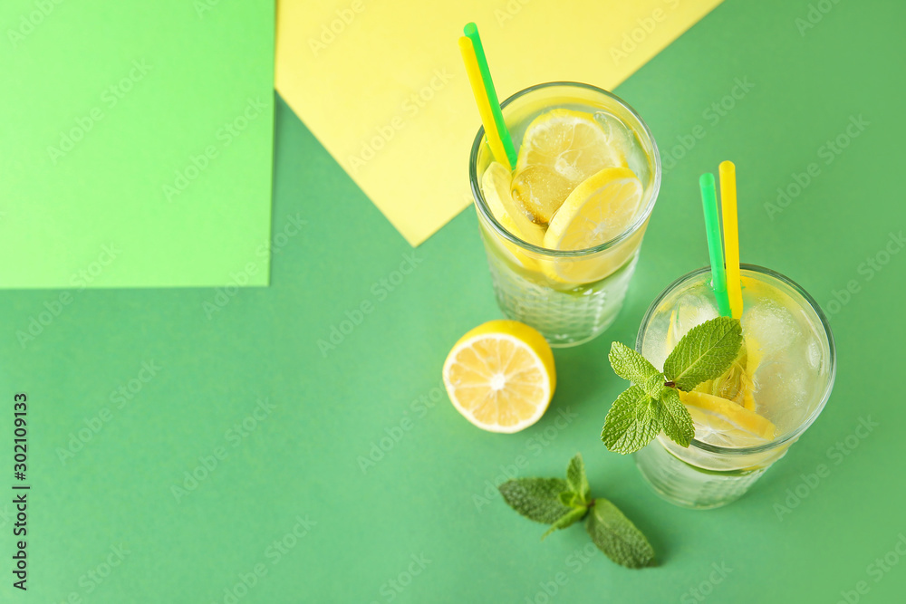 Glasses of fresh lemonade on color background
