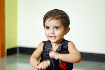 Wall Mural - cute Indian baby girl playing at home and showing multi pal expression