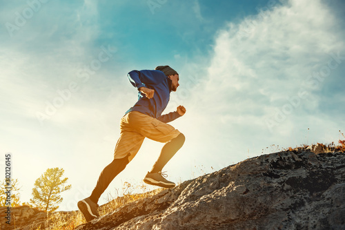 Cuadros en Lienzo Skyrunner skyrunning crosscountry concept with young athlete on big rock