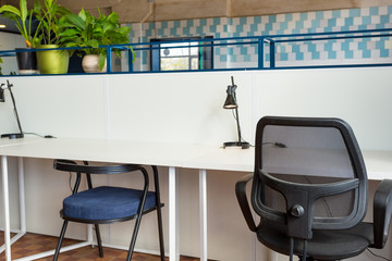 Wall Mural - Loft style office with white brick walls and concrete columns. There is a meeting area with a large white table with black chairs