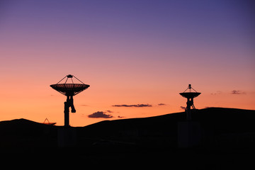 The silhouette of a radio telescope