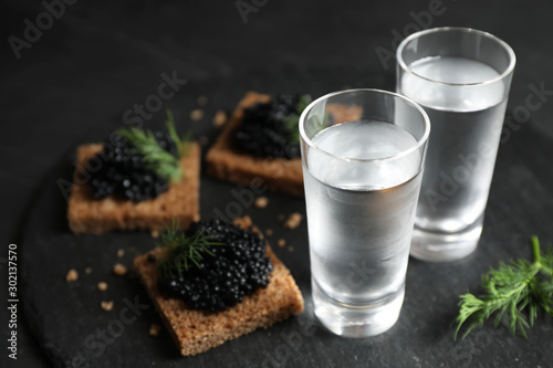 Fotomural Cold Russian vodka and sandwiches with black caviar on table, closeup