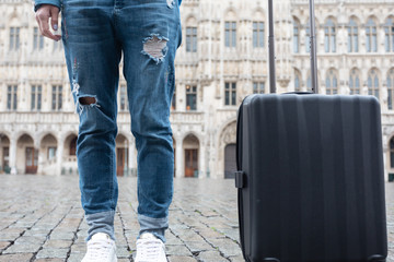 Wall Mural - Woman tourist goes with a suitcase at the Grand Place in Brussels, Belgium