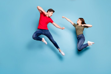 Full size photo of crazy man two people woman man spouses disagree jump fight kick boxing wear green red t-shirt denim jeans sneakers isolated over blue color background