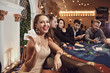 Girl with cards in her hands smiling plays poker in a casino.