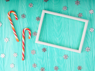 Wall Mural - white frame on blue wooden background, near Christmas decor, Christmas canes, stars. Template to insert text for happy new year greetings