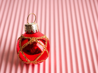 Canvas Print - red Christmas ball on pink background, corrugated ribbed paper, new year and Christmas concept, new year greeting card