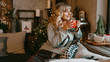 © brillianata - Young woman in plaid with cup of hot tea in a Christmas cozy interior. The concept of preparation for the holidays, Make a wish and dream