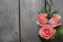 Three Pink Roses In A Rustic Background. Roses On A Gray Wooden Background