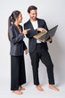 © Ranta Images - Full body shot of happy multi ethnic business couple working with laptop together