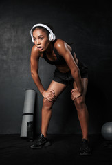 Wall Mural - Confident young african fitness woman resting after workout