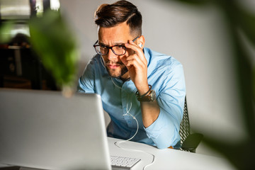 Wall Mural - Young man sitting in his office	