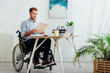 © LIGHTFIELD STUDIOS - Man in wheelchair looking at papers at workplace