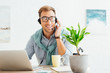 © LIGHTFIELD STUDIOS - Smiling call center operator in wheelchair talking on headset at workplace