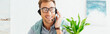 © LIGHTFIELD STUDIOS - Smiling call center operator talking on headset, panoramic shot