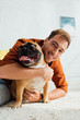 © LIGHTFIELD STUDIOS - Man hugging french bulldog and smiling at camera