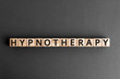 Hypnotherapy - word from wooden blocks with letters, therapy under hypnosis hypnotherapy concept,  top view on grey background