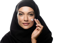 Young Muslim Woman In Hijab Applying Cosmetic Cream On Chick Isolated On White